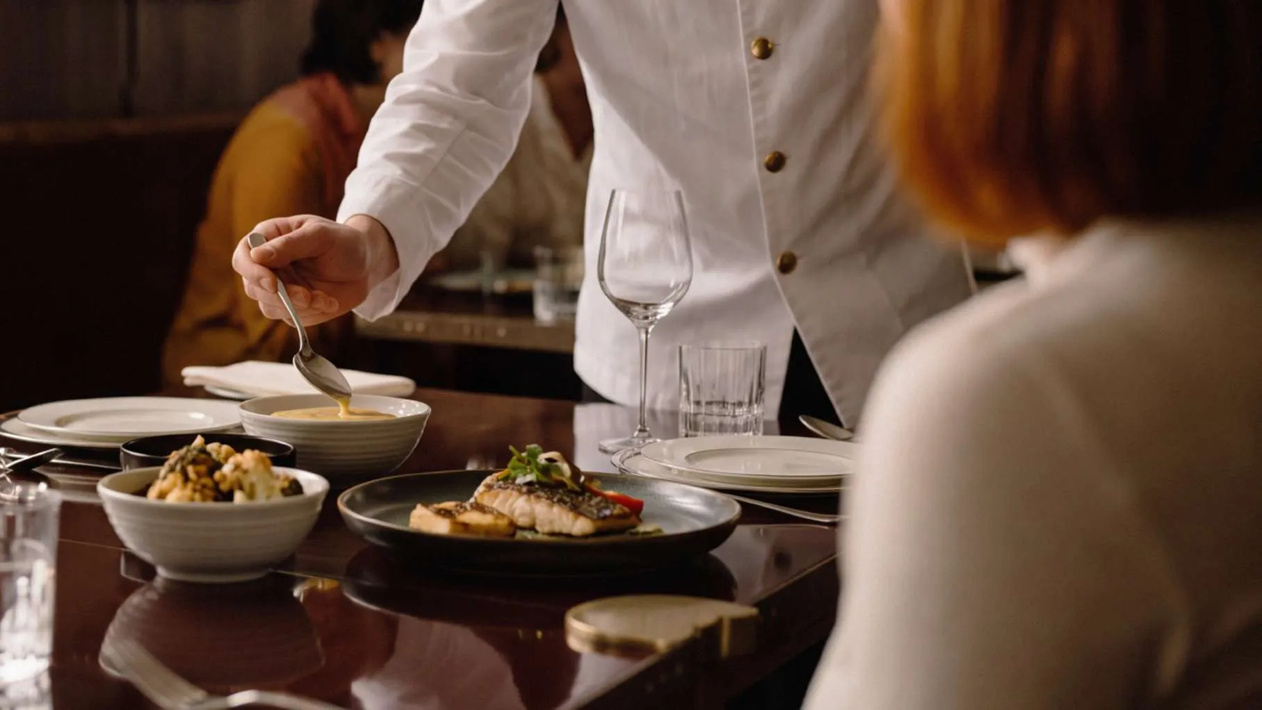 Chef plating a dish in the gourmet food hall